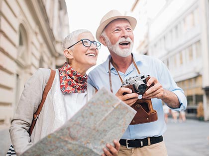 Senior couple looking at a map on vacation in Europe